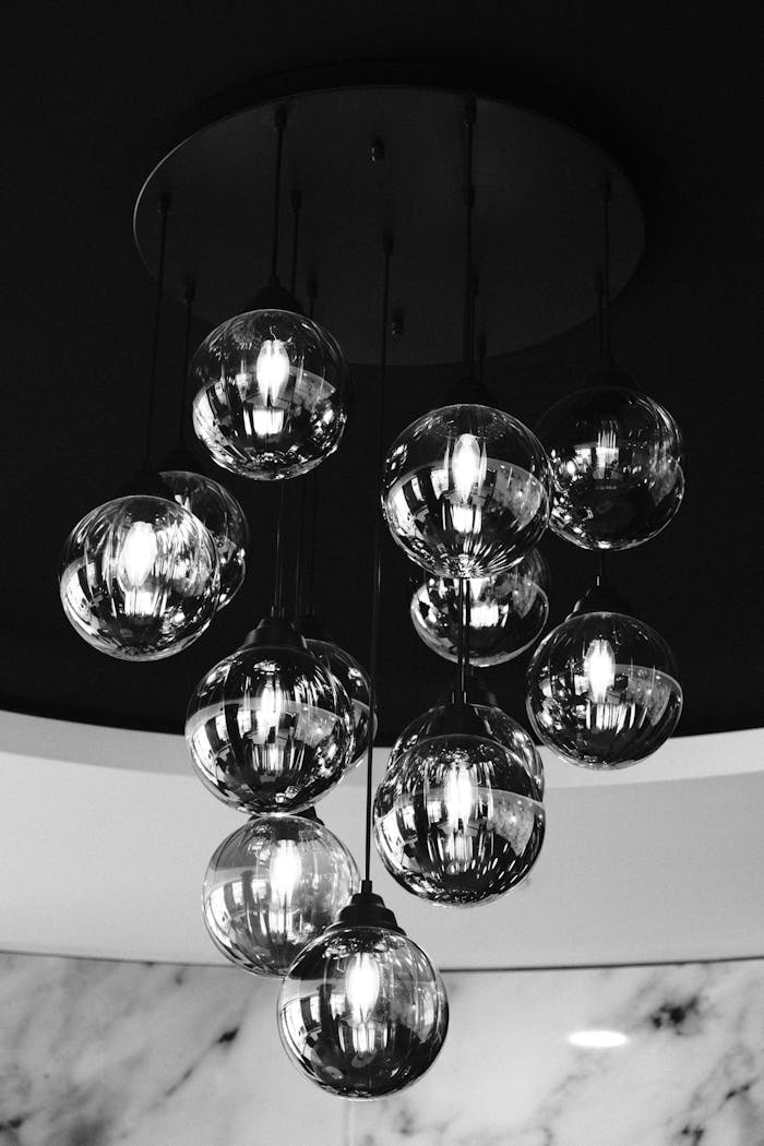 Close-up of a chic black and white glass chandelier with hanging bulbs.